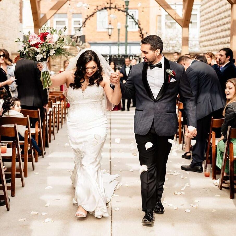 Newlyweds celebrate at outdoor wedding ceremony in The Urb Garden at Mercantile Hall.