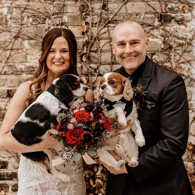 Newlyweds pose with their dogs in The Urb Garden at Mercantile Hall.