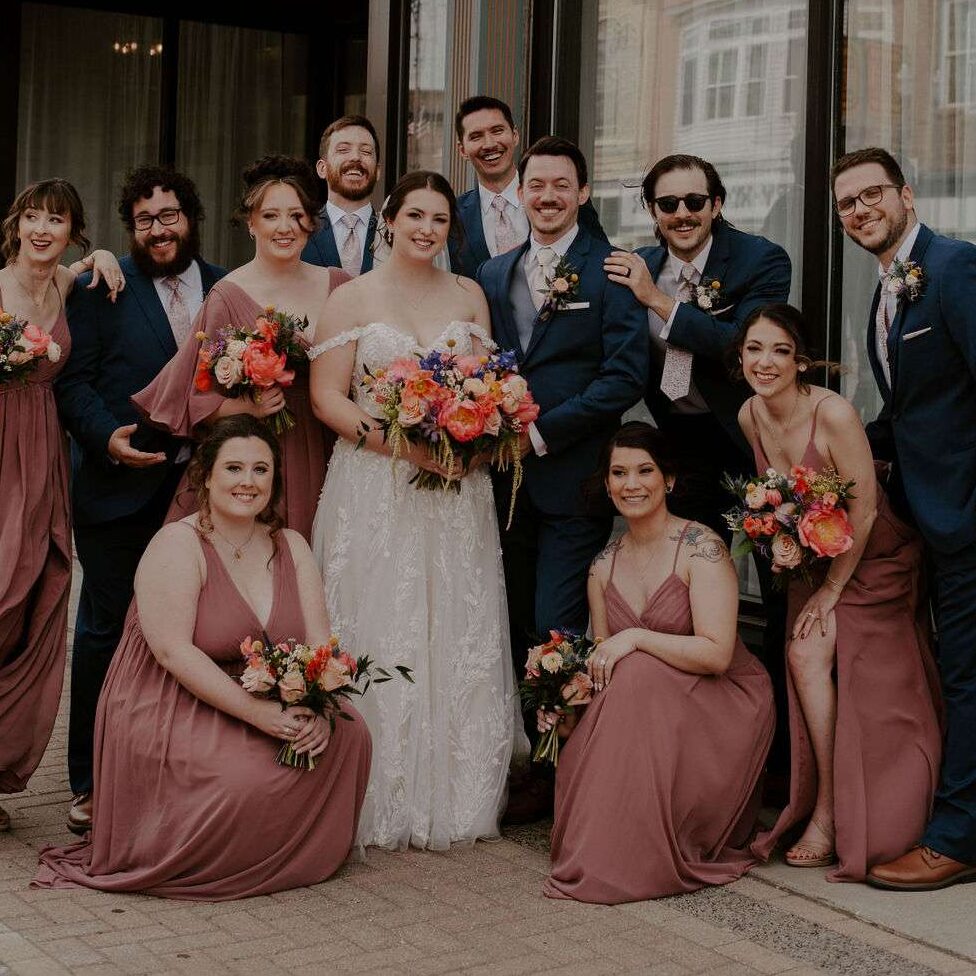 Wedding party poses in front of Mercantile Hall.