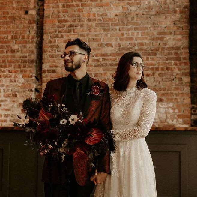 Couple poses by the windows in Mercantile Hall.