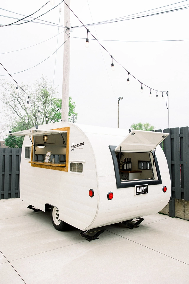 Vintage white camper bar named Suesanna parked on patio at Mercantile Hall in Burlington, WI