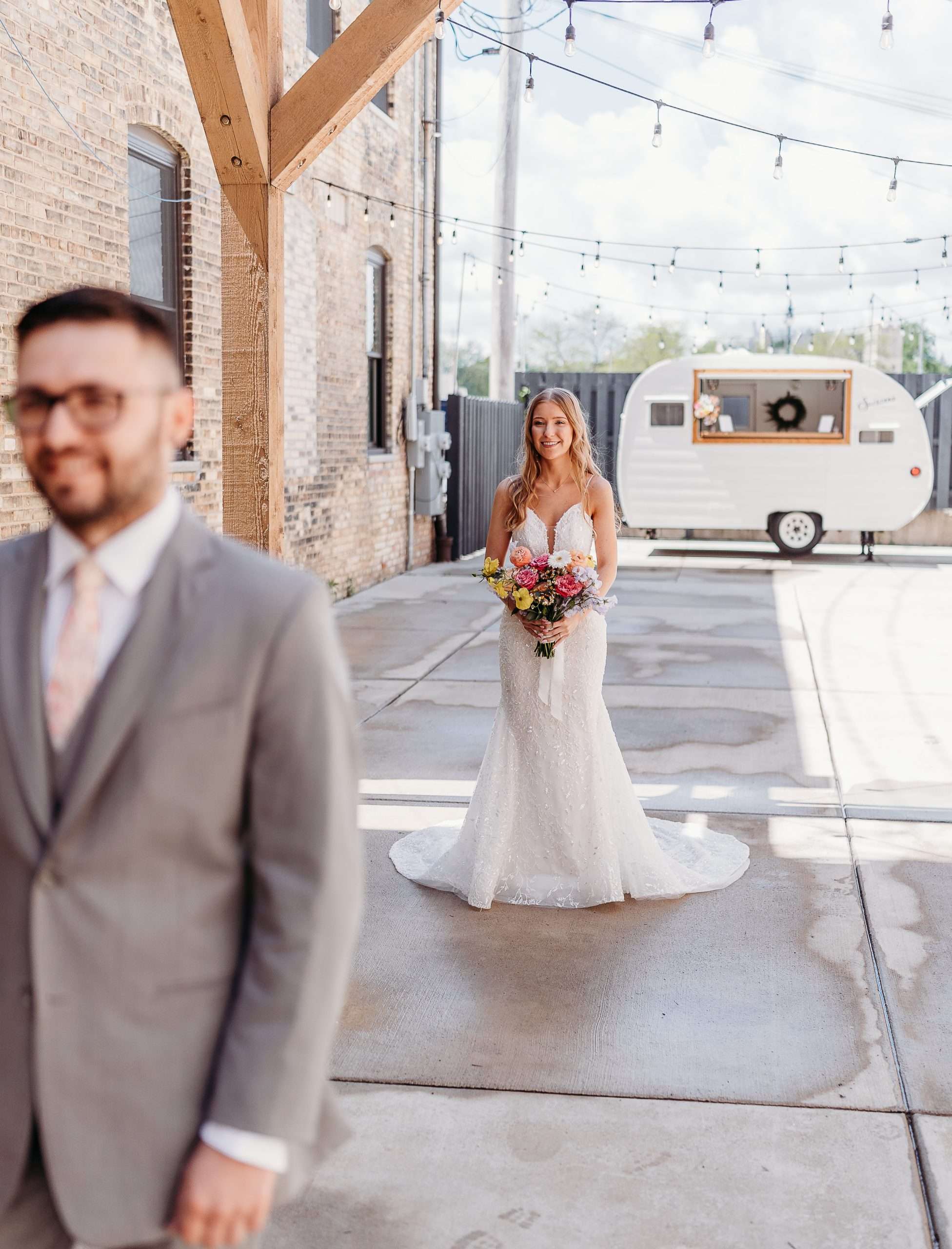 Bride approaching groom from behind for first look at outdoor wedding venue