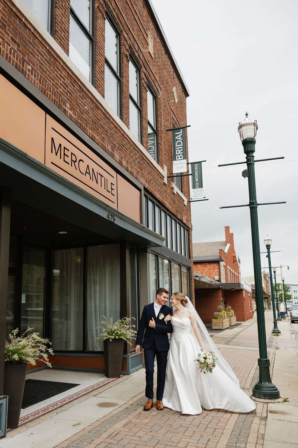 Bride and groom walking outside Mercantile Hall wedding venue in downtown Burlington, Wisconsin