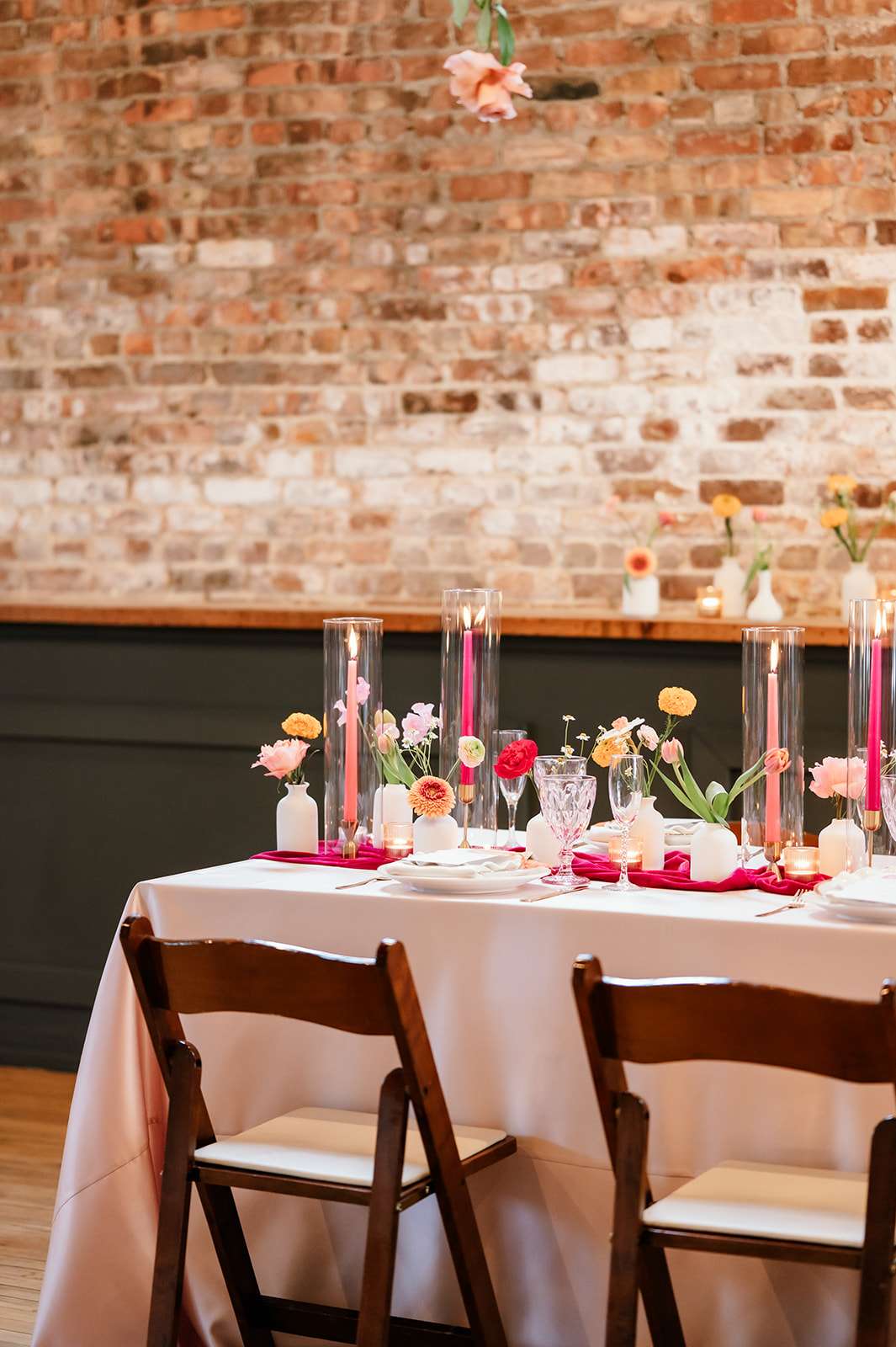 Full reception table styled with pink velvet runner and individual floral bud vases at Mercantile Hall